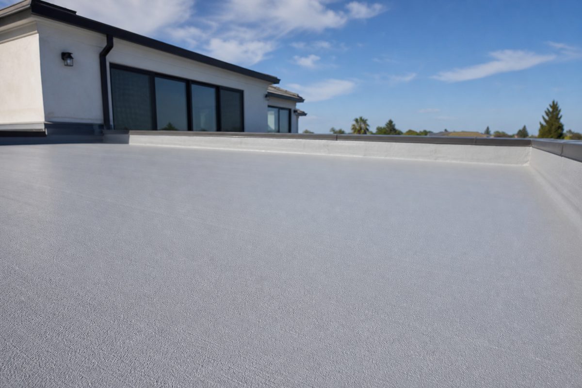 Low-slope residential roof with fresh gray membrane coating